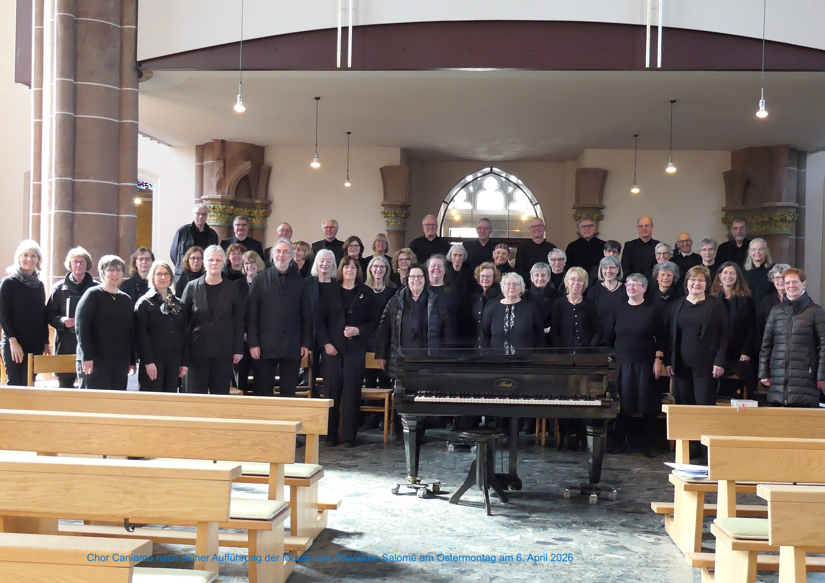 Mehrere Personen in schwarzer Gardrobe stehen unter der Orgelempore in der Kirche Zu den heiligen Schutzengeln.