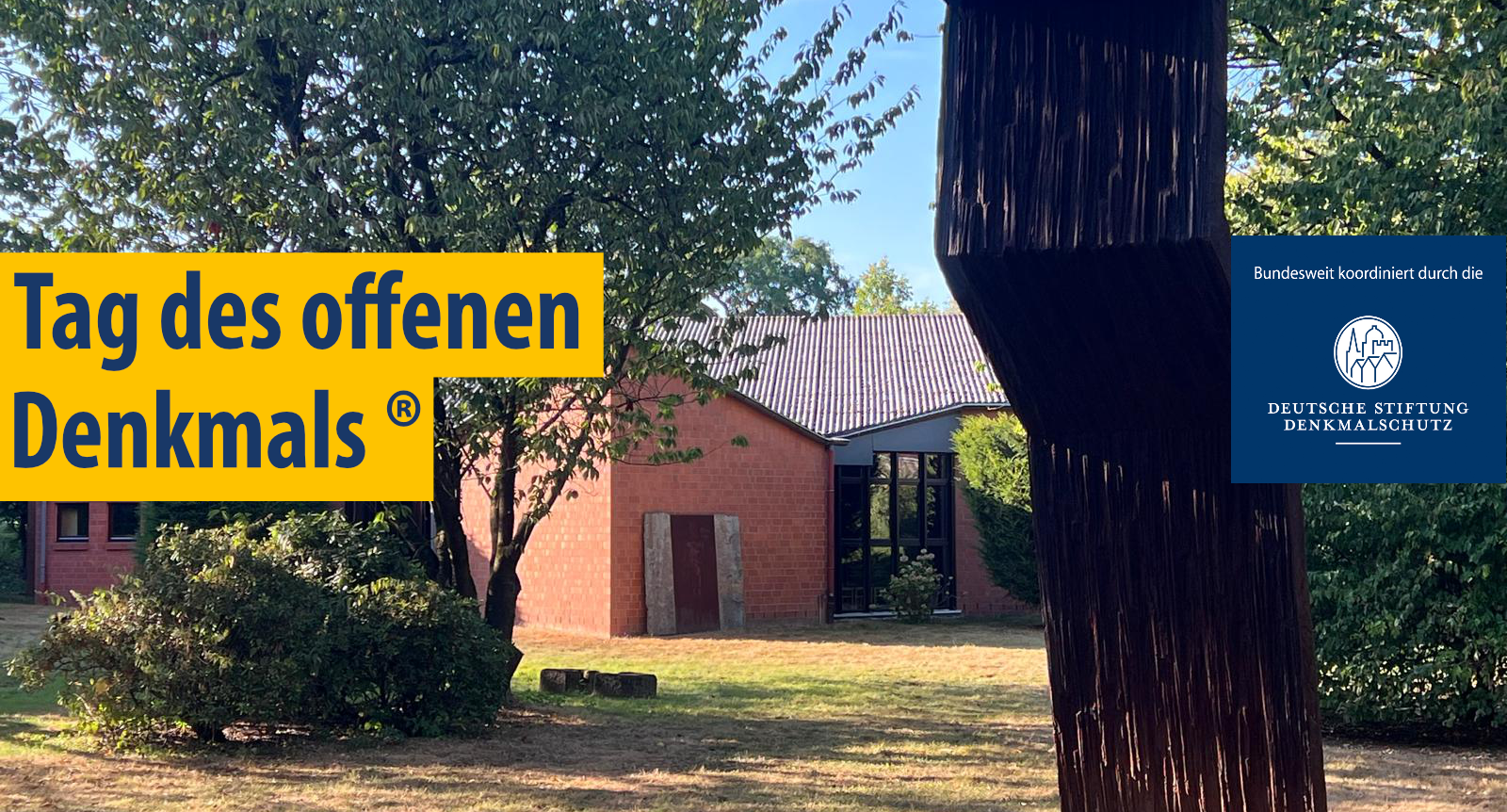 Skulptur aus dunklem Material vor einem roten Backsteingebäude mit Bäumen und gelbem Schriftzug 'Tag des offenen Denkmals (R)' sowie blauem Einstecker mit 'bundesweit koordiniert durch die Deutsche Stiftung Denkmalschutz'.