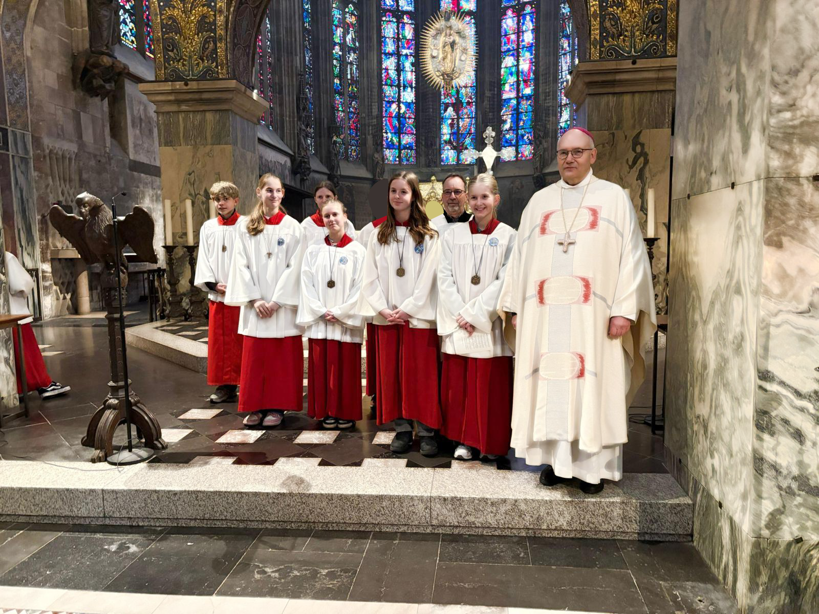 Im Aachener Dom vor dem Karlsschrein stehen mehrere Messdiener:innen und Bischof Dr. Helmut Dieser