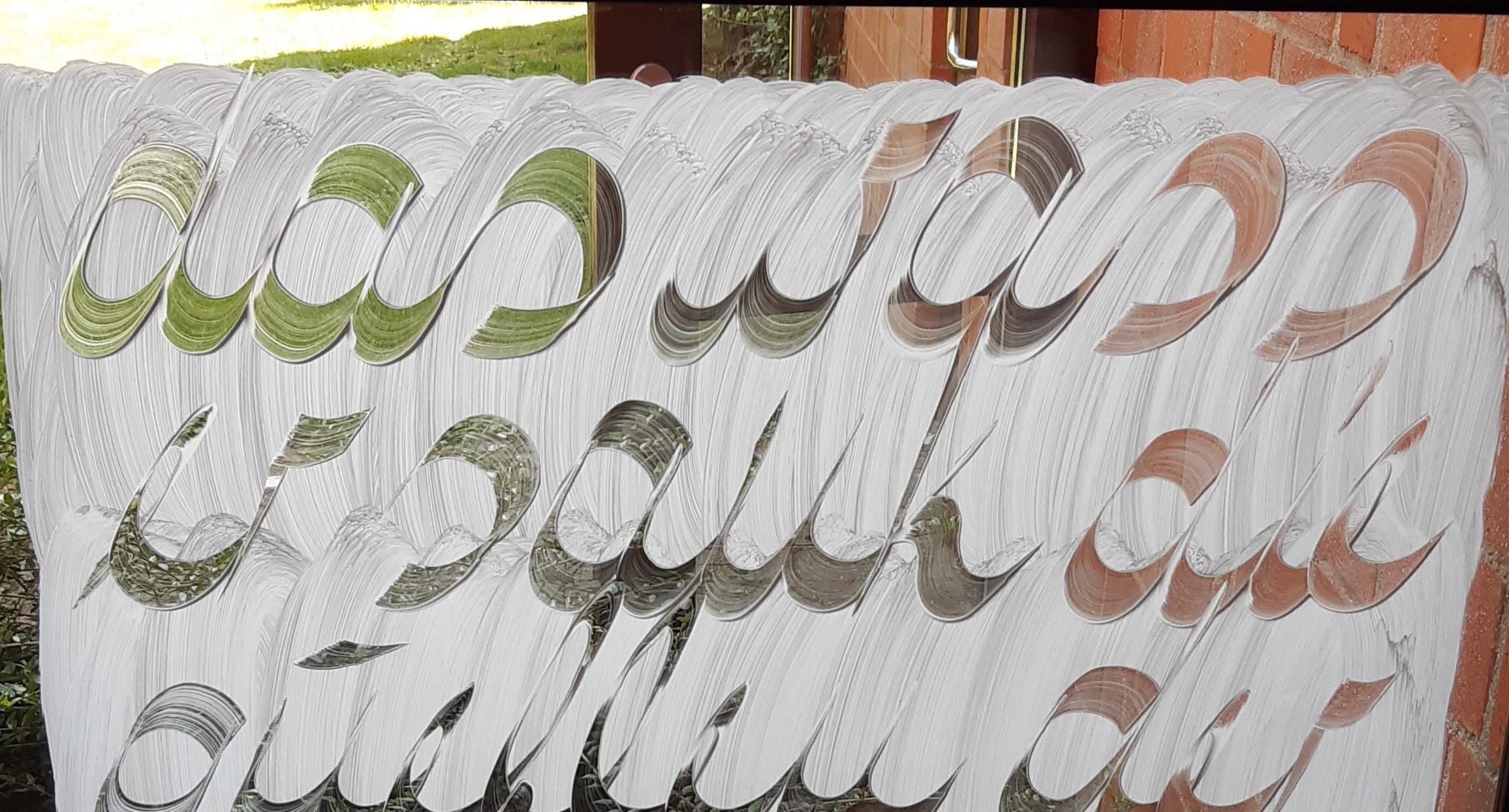Kunstwerk in Pax Christi: Schrift auf Fenster