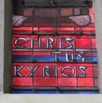 Ausschnitt aus einem Kirchenfenster: Worte 'Christus Kyrios'