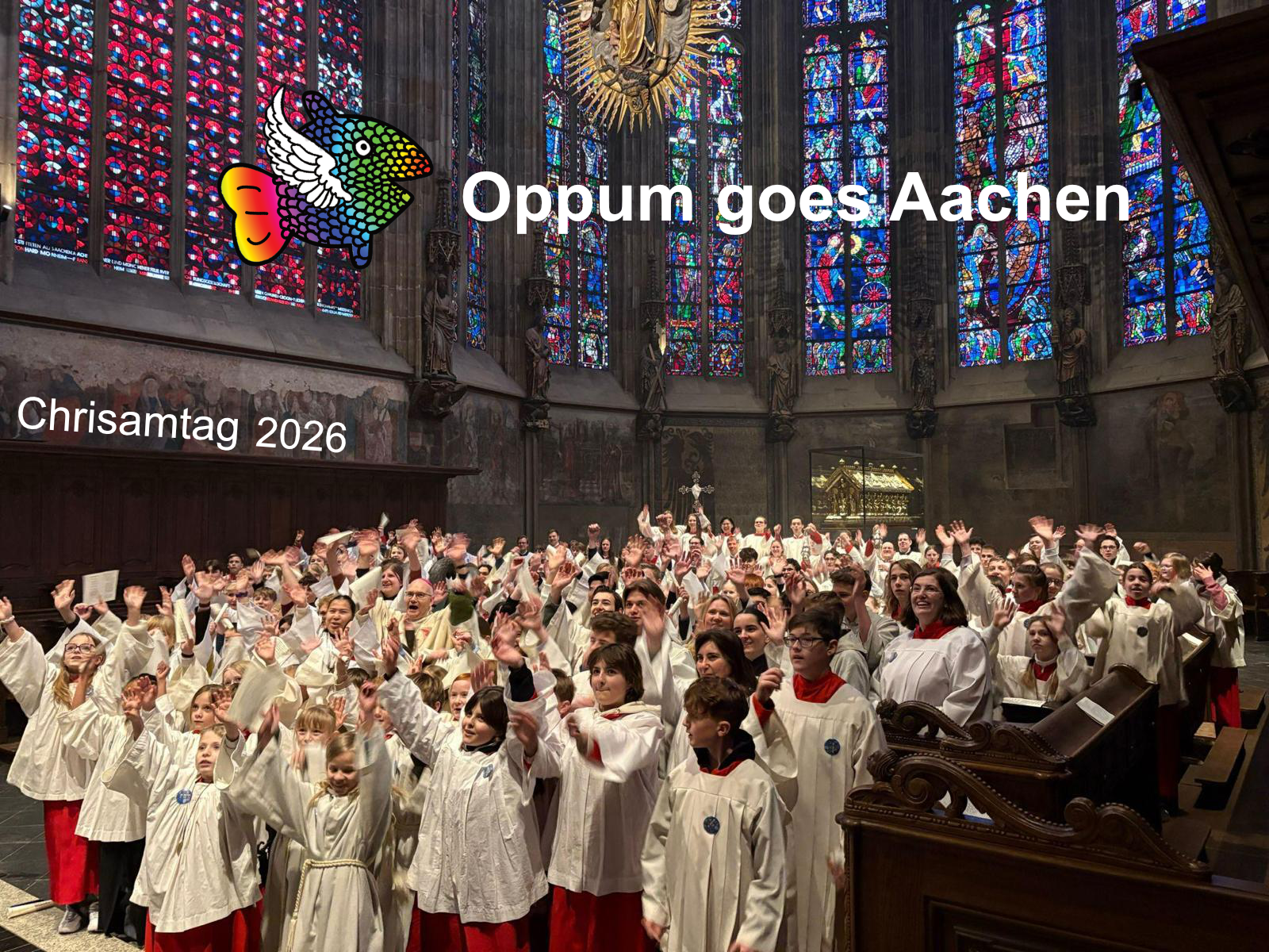 Viele Kinder in Messdienergewändern strecken ihre Hände empor. Im Hintergrund ein Fensterbild im Aachener Dom. Links oben findet sich das Messdienerlogo, daneben der Schriftzug 'Oppum goes Aachen'.