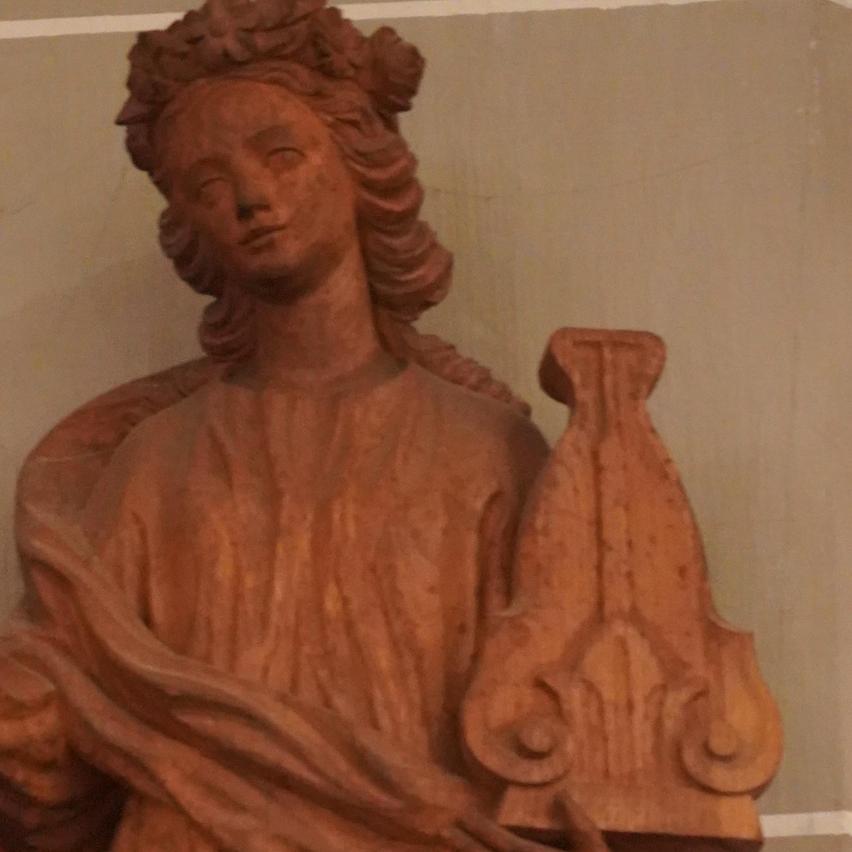 St. Clemens-Kirche: mittelalterlich anmutende Holzfigur St. Cäcilia mit Leier