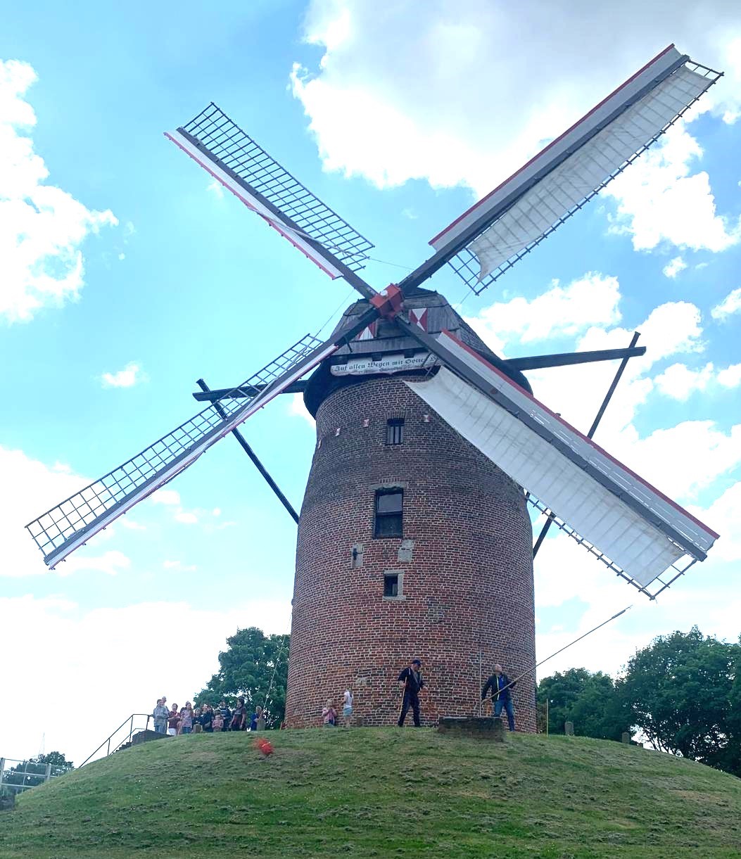 Die Geismühle Krefeld Oppum, im Hintergrund hellblauer Himmel und weiße Wolken.