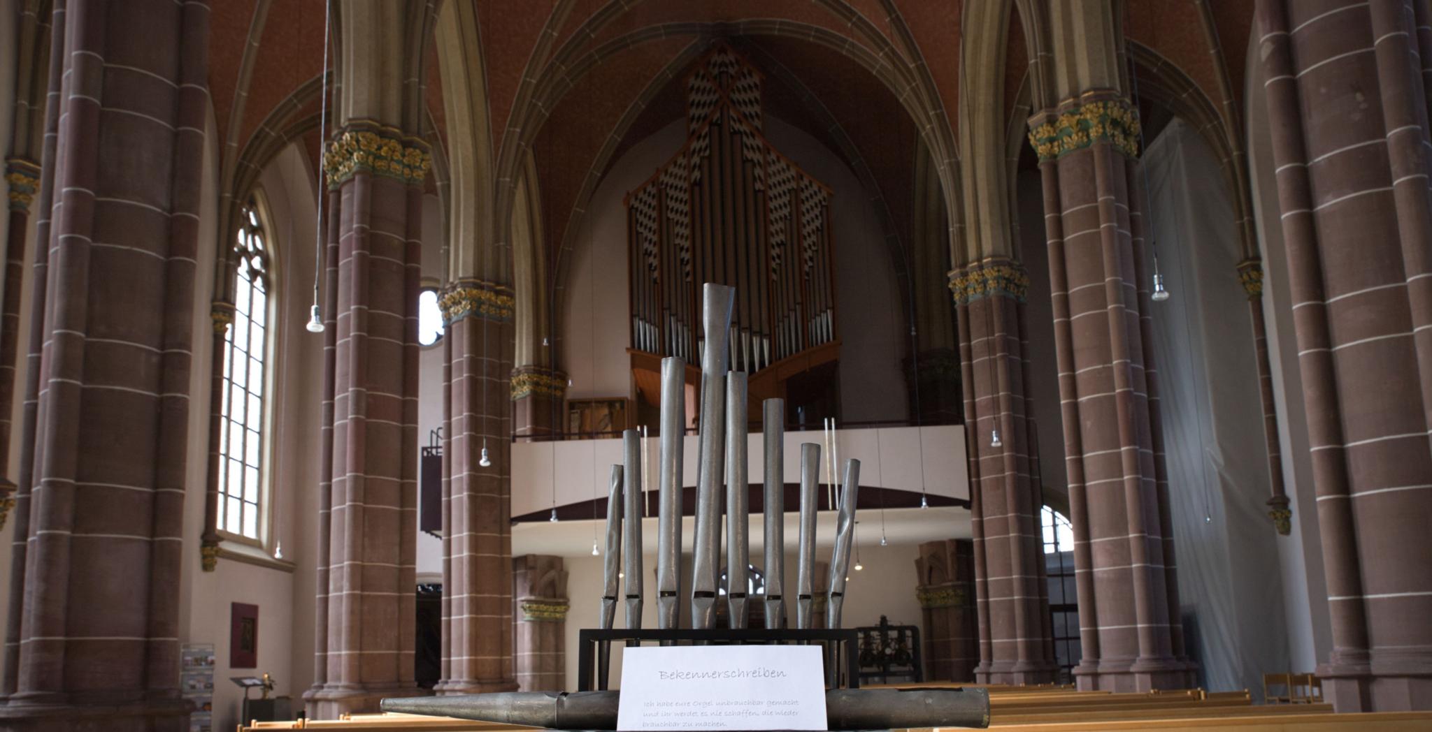 Innenraum einer Kirche mit Orgel und Orgelpfeifen und Brief.