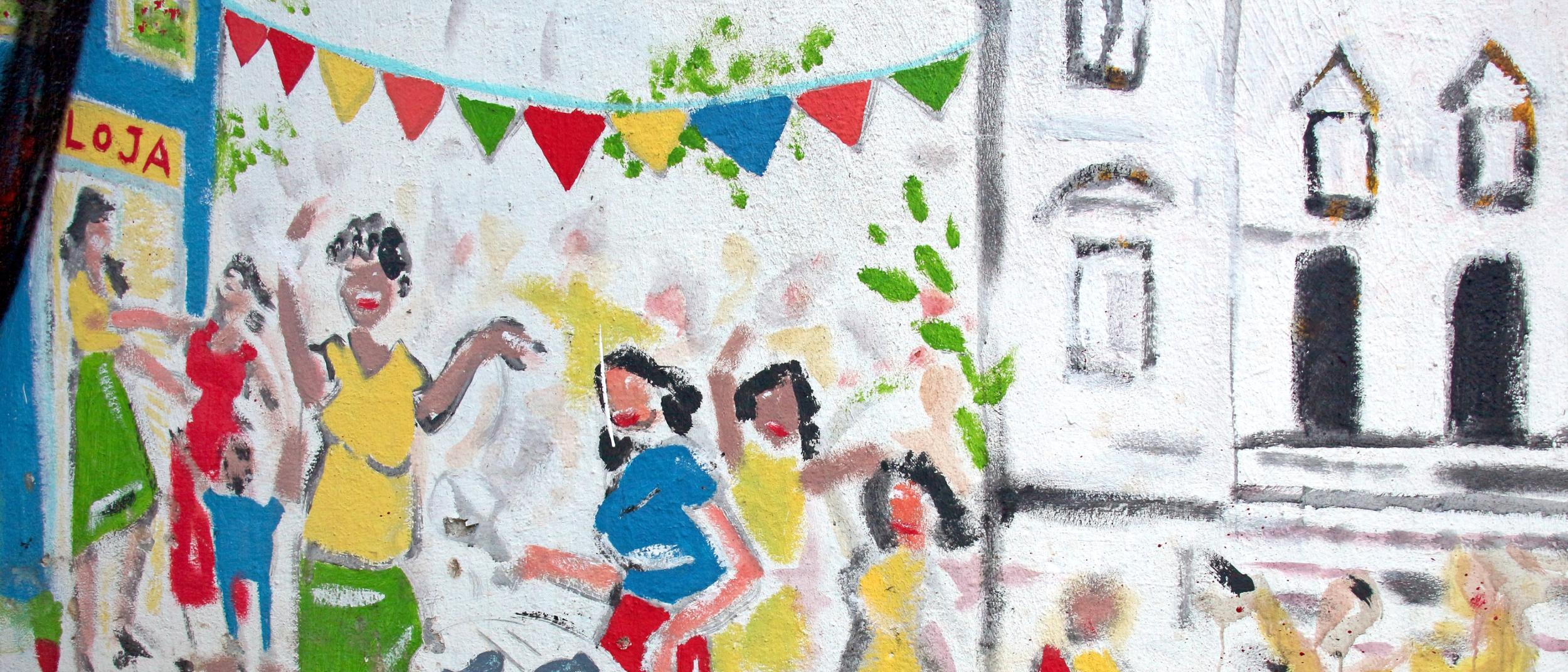 Buntes Wandgemälde mit tanzenden Menschen und fröhlichen Festtagsfahnen.